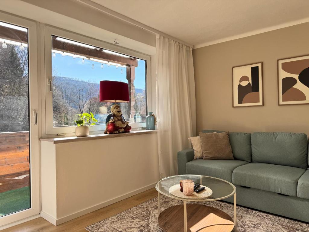 a living room with a couch and a table at Ferienwohnung Edeltraud, fußläufig zum See und 20 Minuten vom Skigebiet entfernt in Döbriach