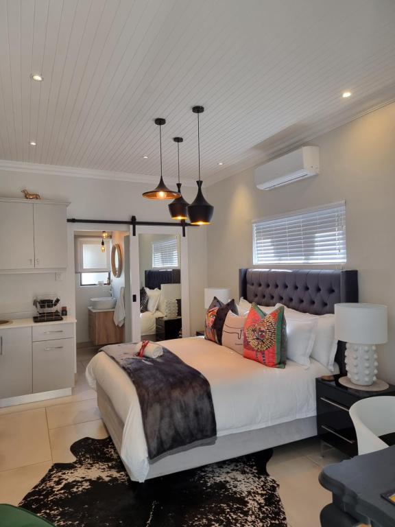 a bedroom with a large bed and a kitchen at Picasso Dreams in Kimberley