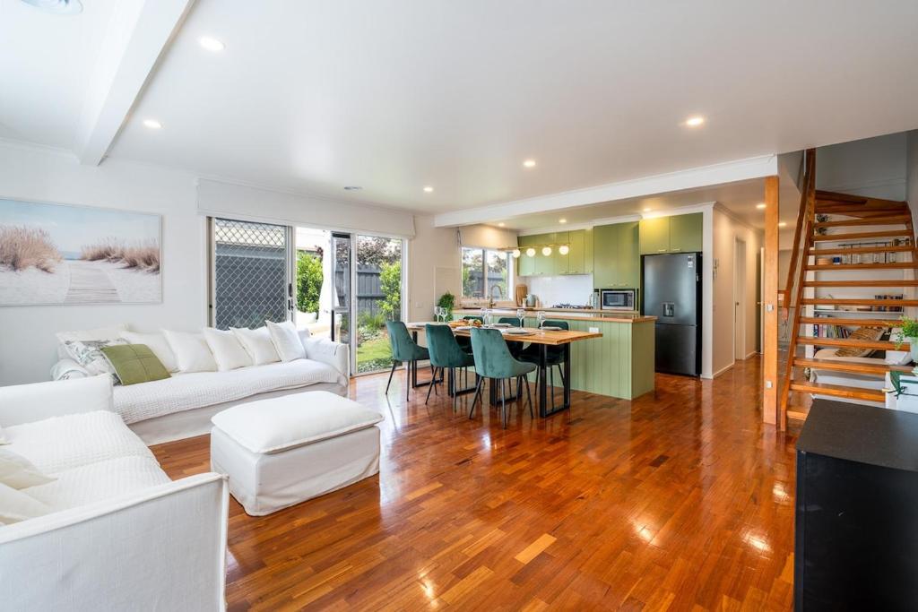 a living room with a white couch and a table at Fireplace & Winter Swells, 800m to the beach in Ocean Grove