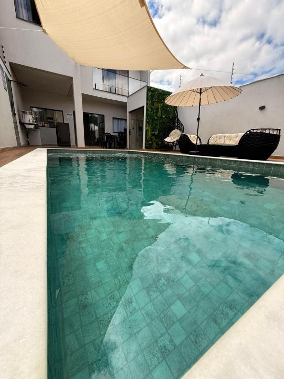 a swimming pool with an umbrella in a house at Espaço prime piscina aquecida in Sorocaba
