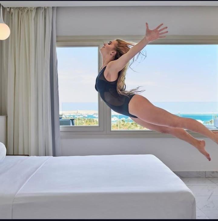 a woman jumping on a bed in a bedroom at Juliana Beach Hurghada in Hurghada
