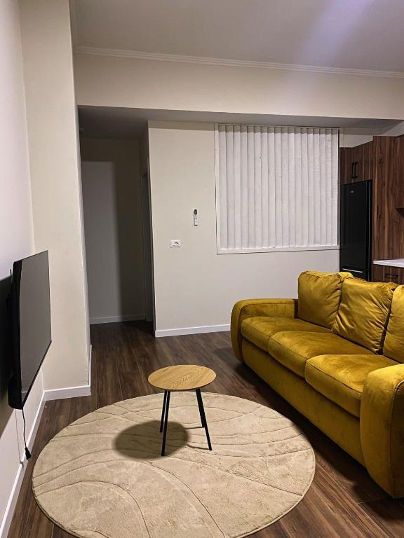a living room with a yellow couch and a table at stefanias apartment in Tirana