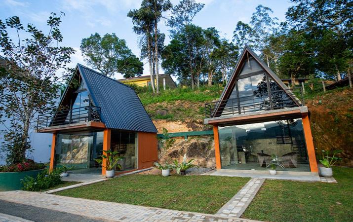 a small house with glass windows on a hill at Green Infinity Resort in Diyatalawa