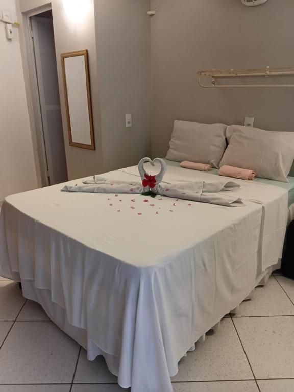 a bed with a white table with a flower on it at Hospedagem Terral Beach Canoa Quebrada in Aracati