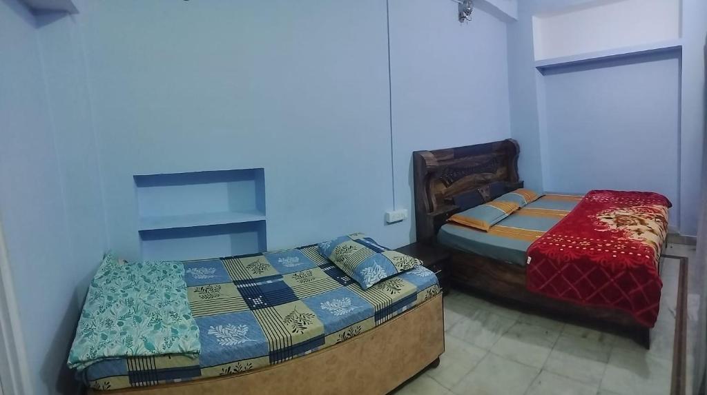 two twin beds in a room withthritisthritisthritisthritisthritisthritisthritisthritisthritis at Sunrise Guest House in Jaipur
