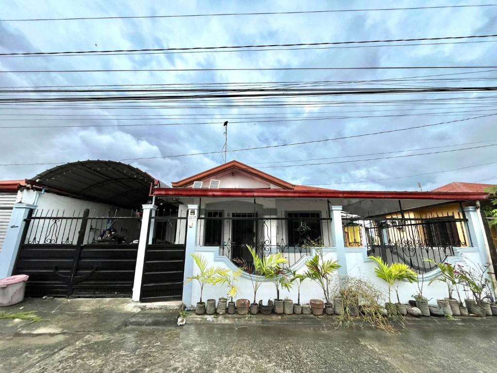 a white house with a red roof at Triple K Transient House in Butuan
