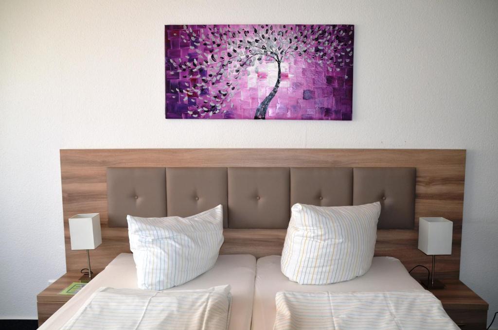 um quarto com uma cama com um quadro roxo na parede em Gästehaus Pauline em Berlim