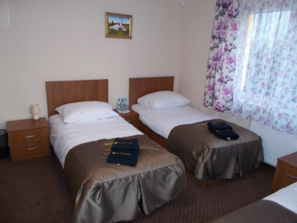 una camera d'albergo con due letti e una finestra di Willa Poniatowskiego a Grodzisk Mazowiecki