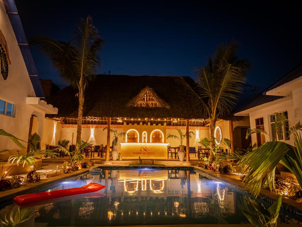 a villa with a swimming pool at night at Kendwa Sky Hotel in Kendwa