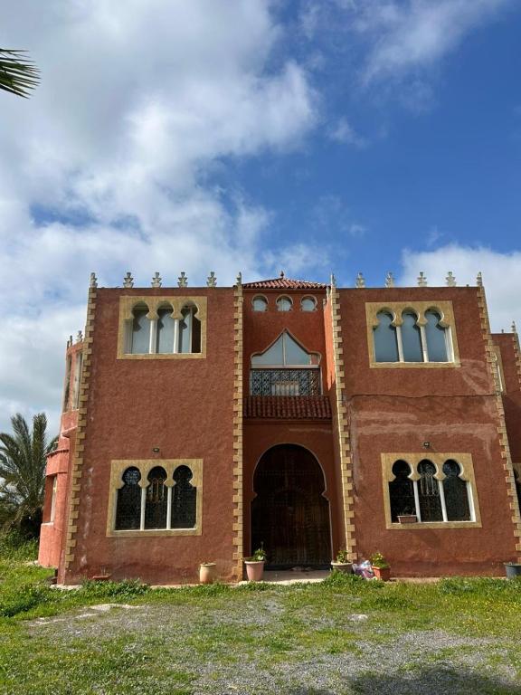 a red brick building with a porch and a balcony at chitoui in Ben Slimane