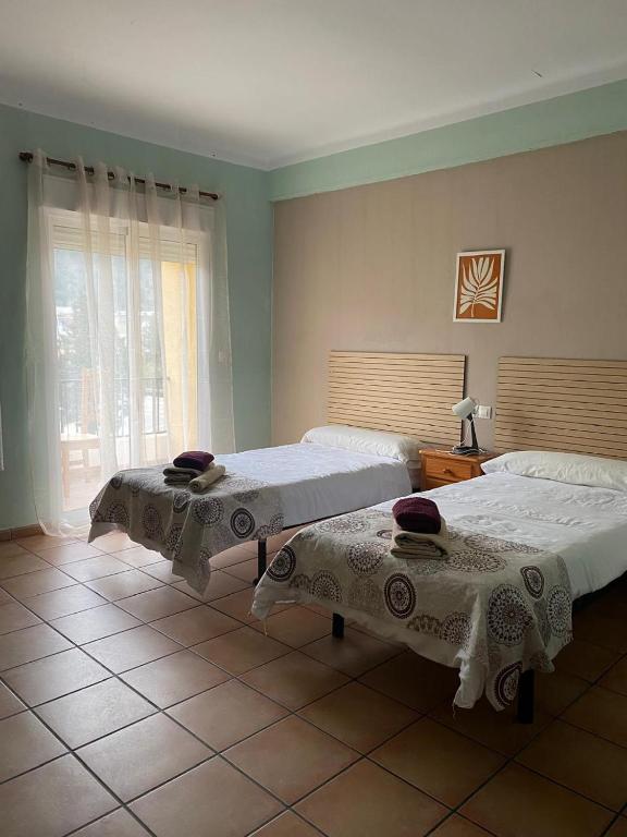 a bedroom with two beds and a window at Hotel Move Espadan in Azuébar