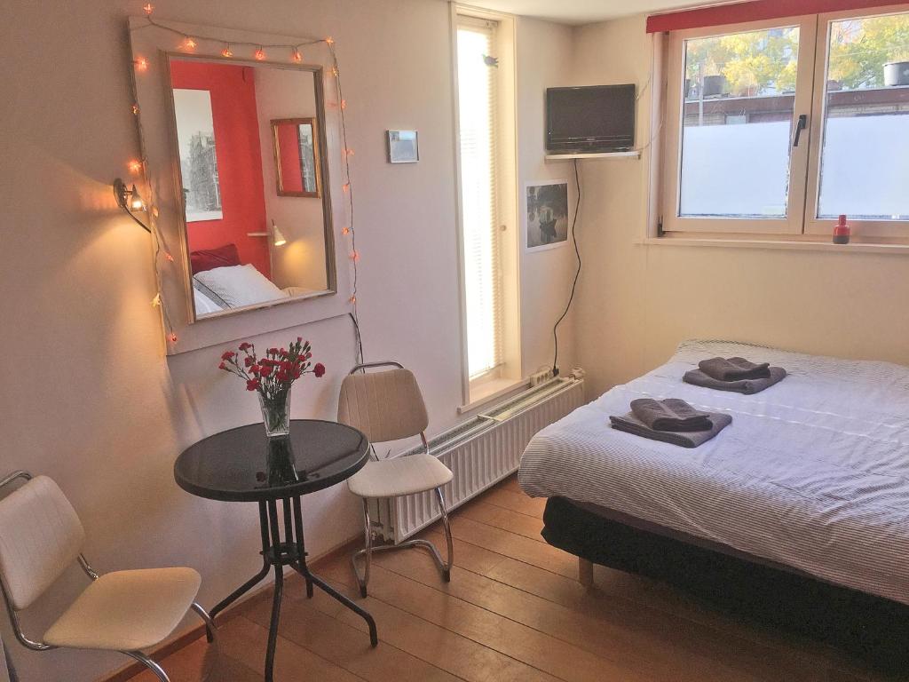 una camera con letto, tavolo e specchio di Houseboat Westerdok ad Amsterdam
