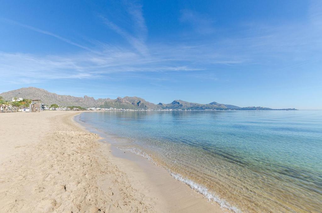 a view of the beach with mountains in the background at YourHouse Llimonera in Port de Pollensa