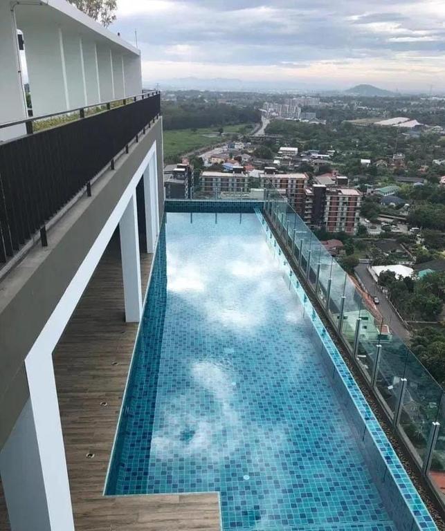 a large swimming pool on the side of a building at Plus Sriracha Condo NEW Building in Si Racha