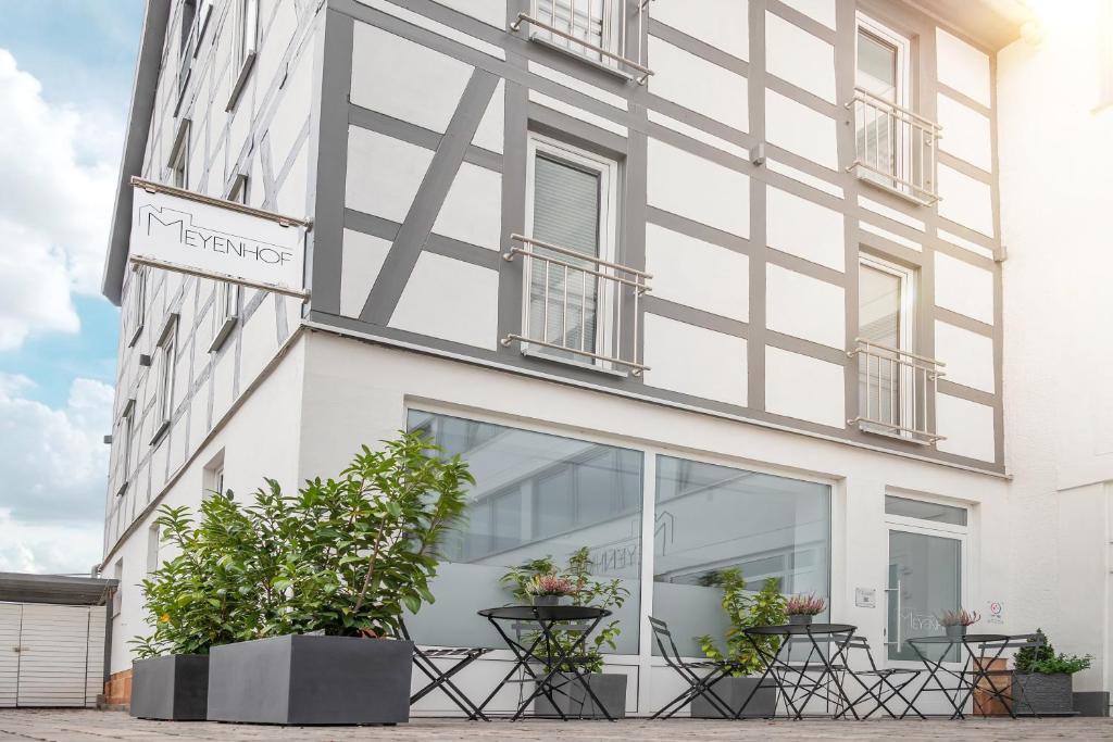 ein weißes Gebäude mit Fenstern und Pflanzen in der Unterkunft Hotel Apartment Ferienwohnung Meyenhof Frankenberg Eder in Frankenberg