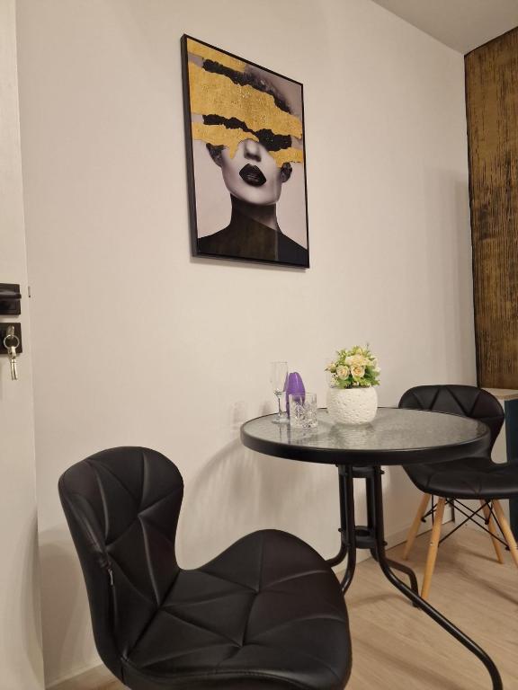 a table and chairs in a room with a painting at Studio Maria in Bucharest