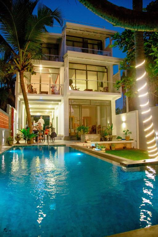 a house with a swimming pool in front of a house at Norea Sands in Bentota