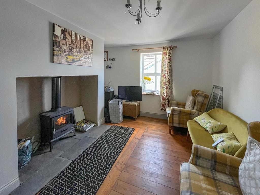 a living room with a fireplace and a couch at Fronisaf - Uk49775 in Llanfair Talhaiarn
