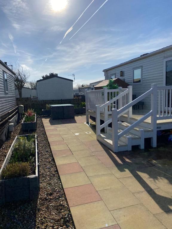 a patio with a white fence and some plants at 230 Unity Holiday Resort 6 Birth cosy and secure property next to all shops and entertainment passes optional in Brean