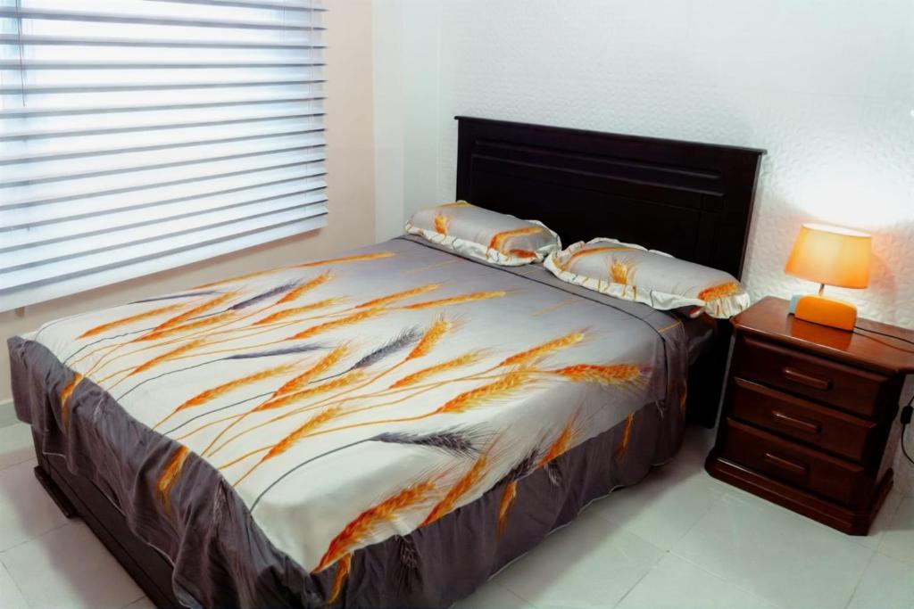 a bedroom with a bed and a night stand with a lamp at Departamento 1 centro de la ciudad in Santo Domingo de los Colorados
