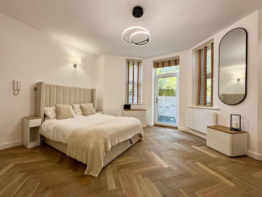 a bedroom with a bed and a large mirror at West Cliff Studio - Private Garden mins from Beach in Bournemouth