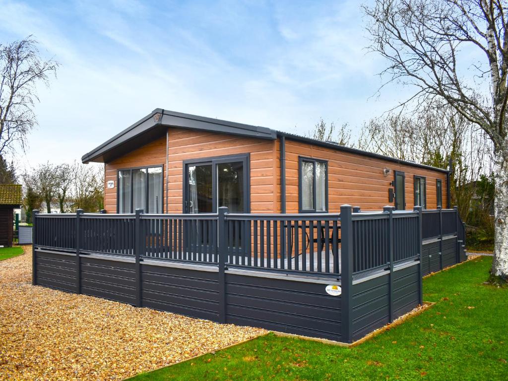 a tiny house with a black fence at Lodge 8 - Uk51076 in Lyme Regis