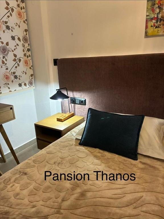 a bedroom with a bed with a black pillow on it at Thanos ,Rooms and Apartments in Ouranoupoli