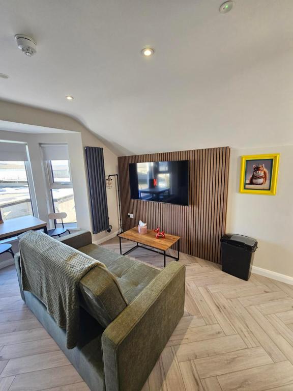a living room with a couch and a tv at West Strand Snug in Portrush