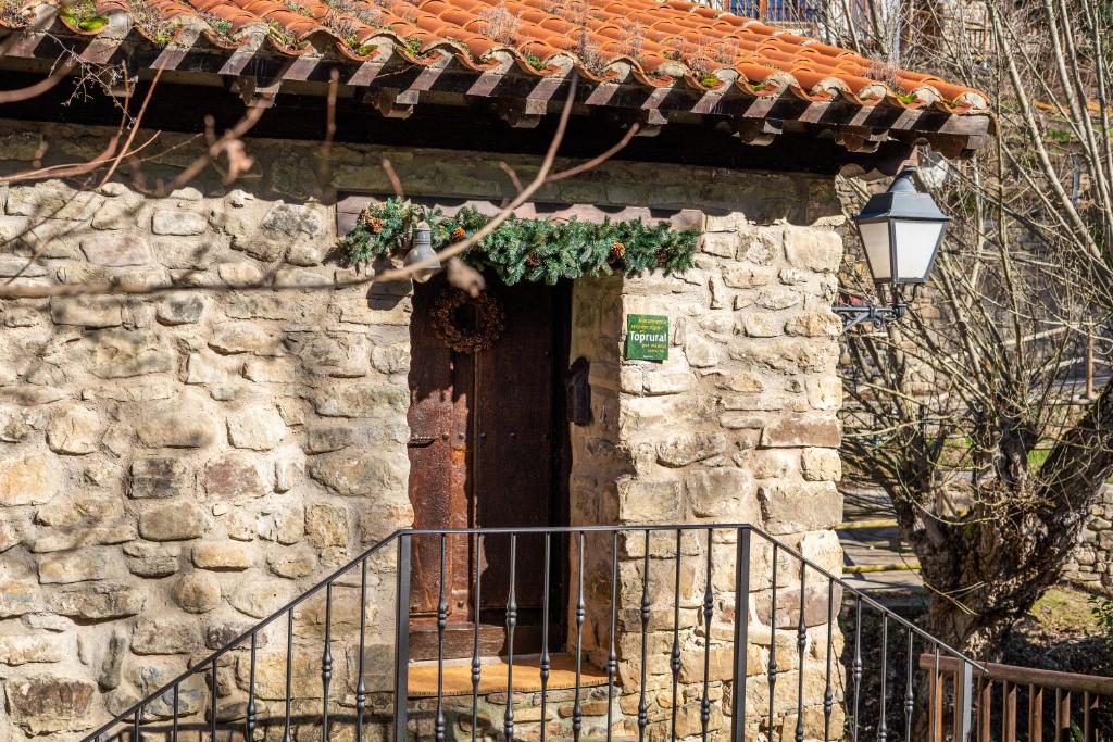a stone building with a door with a wreath on it at Casa Rural Concejos in San Román de Cameros