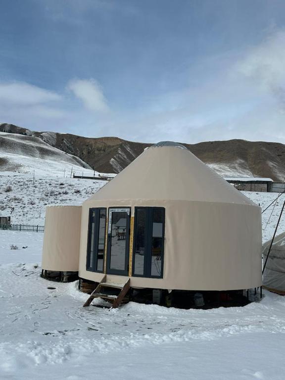 a yurt is covered in snow in a field at Отель 3 in Kurmenty