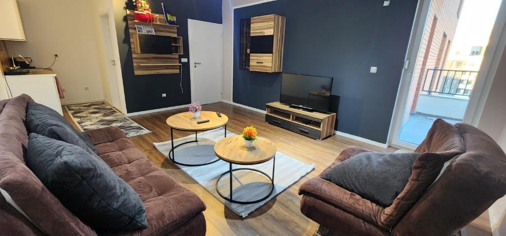 a living room with two couches and a television at Prishtina Apartment in Prishtinë