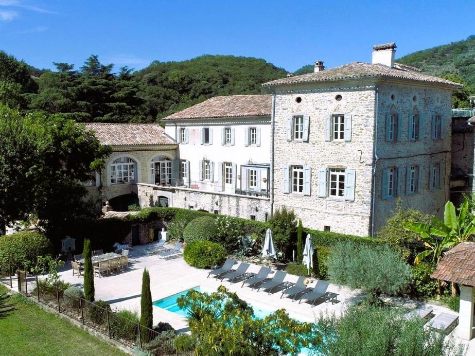 a large stone building with a pool in front of it at Château Meilhen in Les Mages