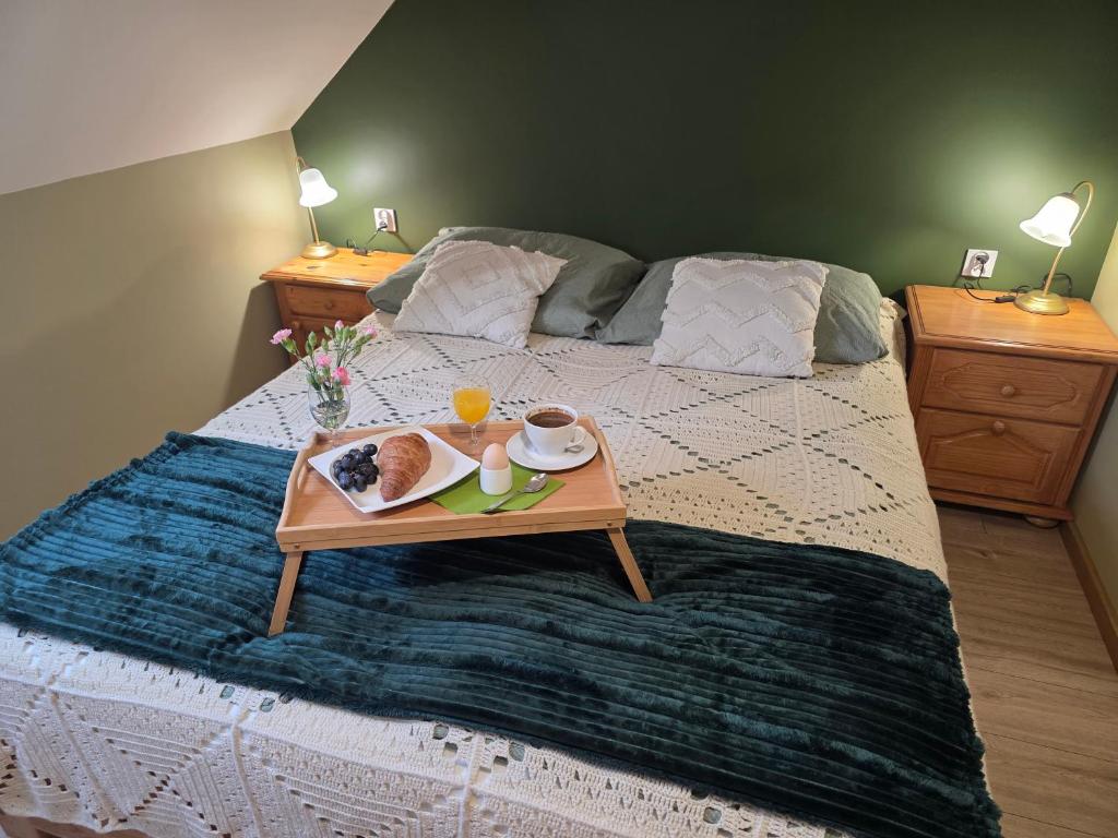 a bed with a tray of food on it at W Olchach - lokal Klon in Wiktorowo