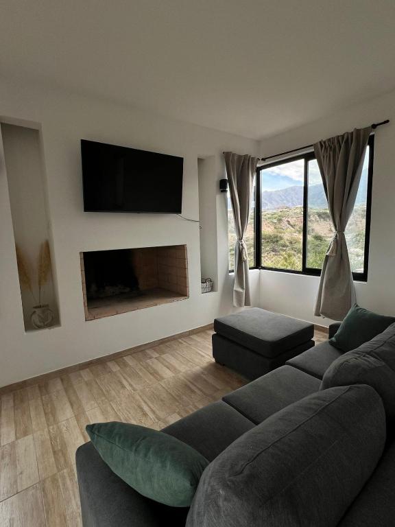 a living room with a couch and a fireplace at Dos Cumbres in Ciudad Lujan de Cuyo