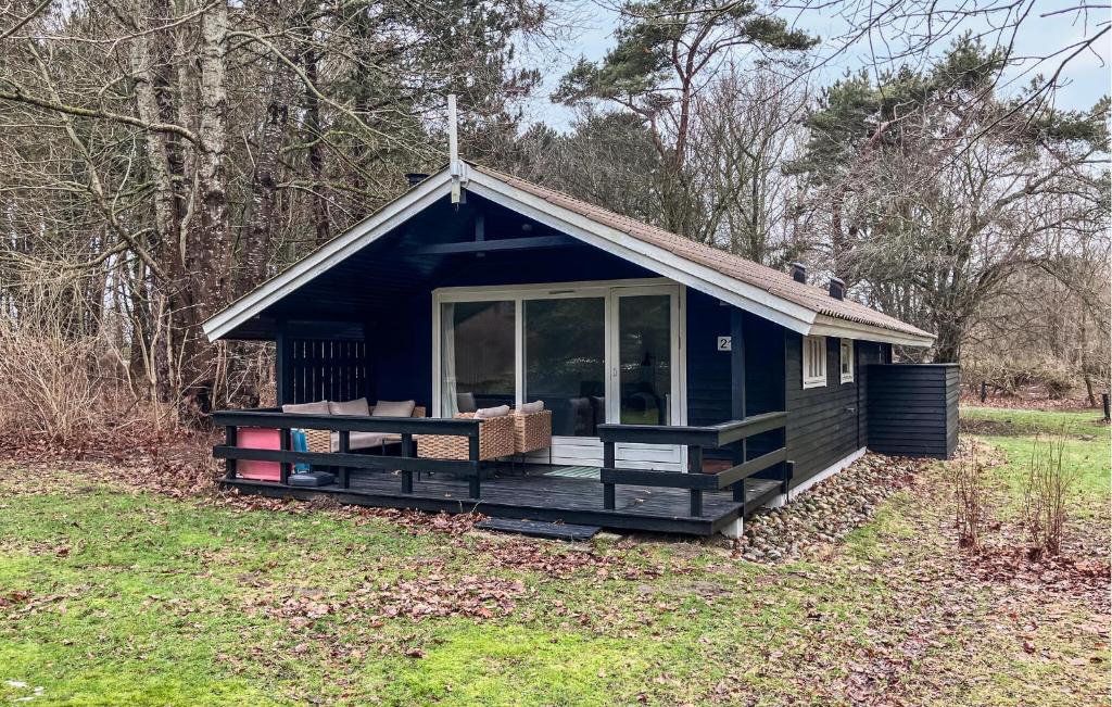 a blue tiny house in a field with trees at 2 Bedroom Nice Home In Hundested in Hundested