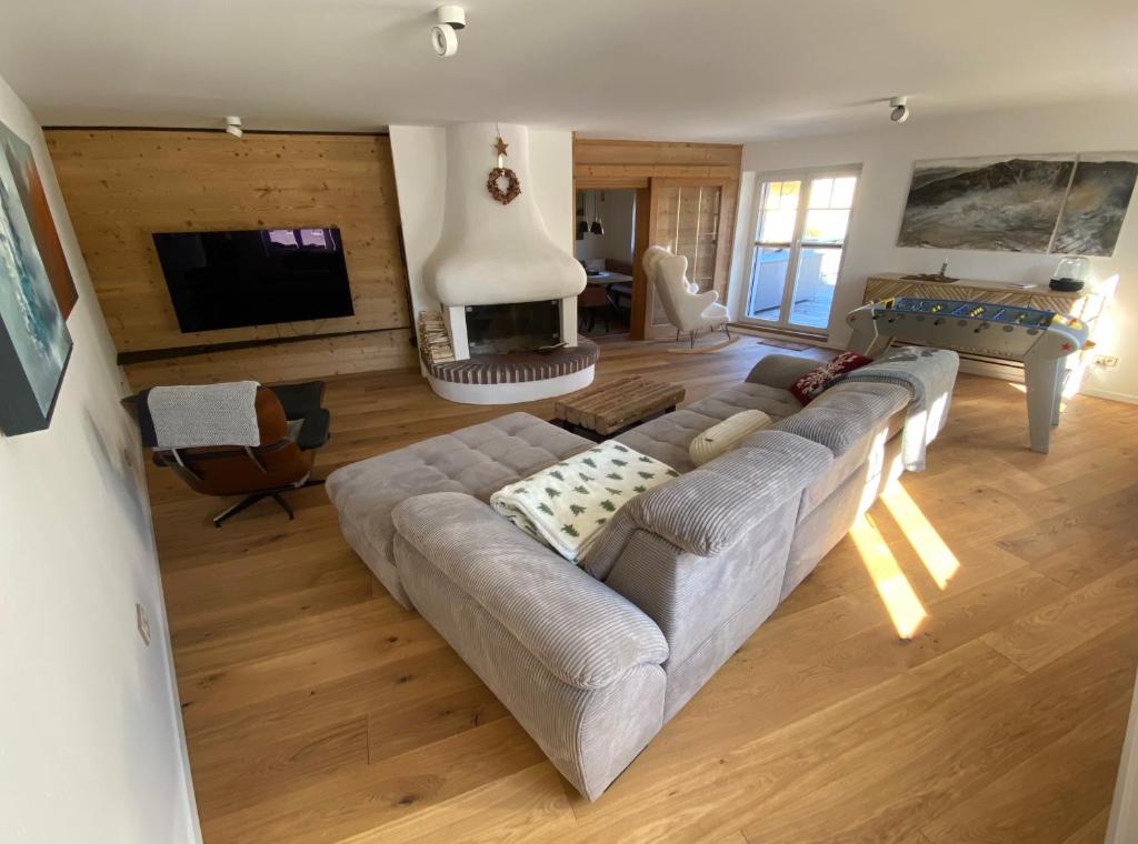 a living room with a large couch and a fireplace at ParkSuite Aflenz Kurort in Aflenz Kurort