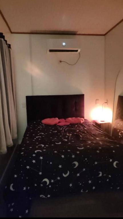a bedroom with a bed with a black comforter at Habitación para pareja in Salinas