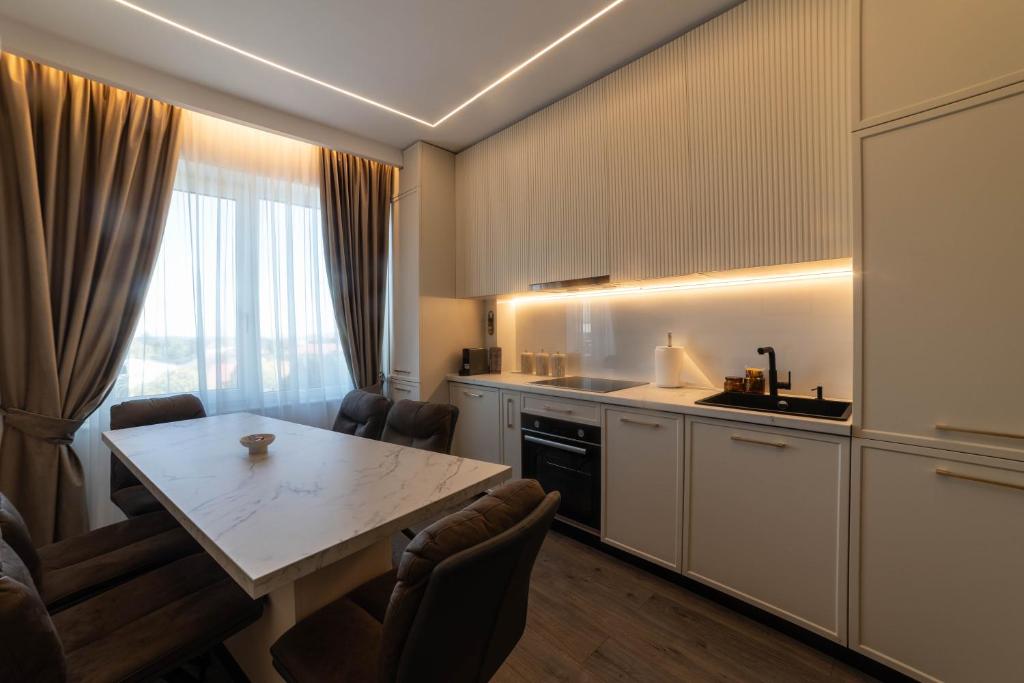 a kitchen with a table and chairs in a room at Cherry Apartments in Iaşi