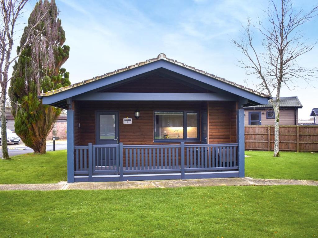 a small house with a fence in a yard at Lodge 1 - Uk51077 in Lyme Regis