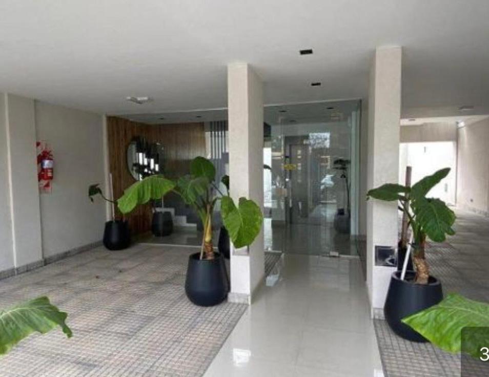 a lobby with two potted plants in a building at Depto temporal in Morón