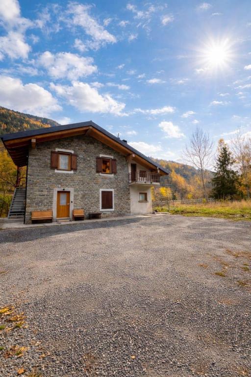 a large stone house with a driveway in front of it at Al Vagone in La Salle
