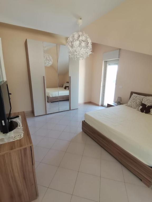 a bedroom with a large bed and a mirror at La casa di Ely in Sarno