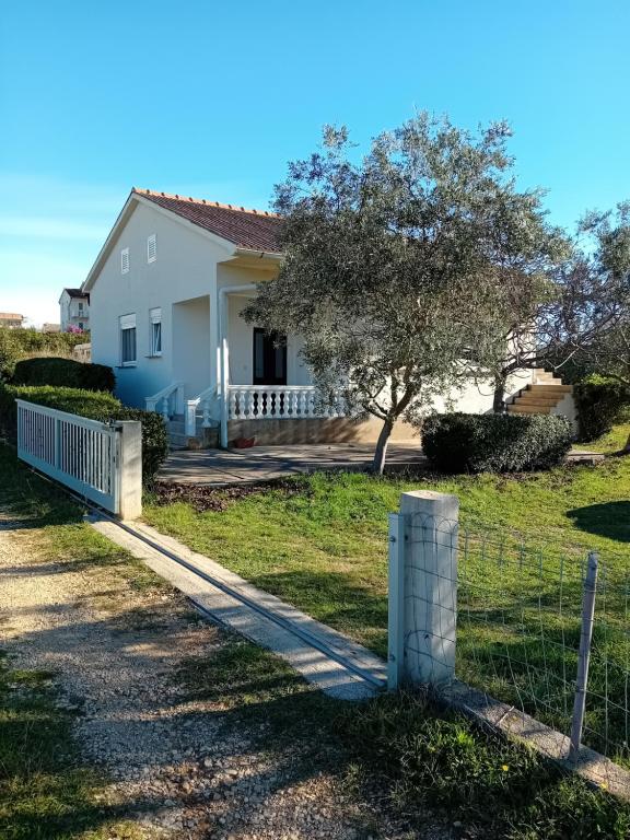 a house with a fence in front of it at Dume in Povljana