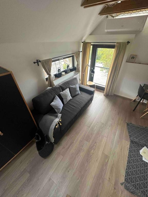 a bedroom with a black bed and a wooden floor at Vörösdió apartment house in Szilvásvárad