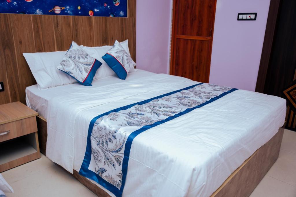 a bed with blue and white pillows on it at Hotel Saraswati in Nautanwa