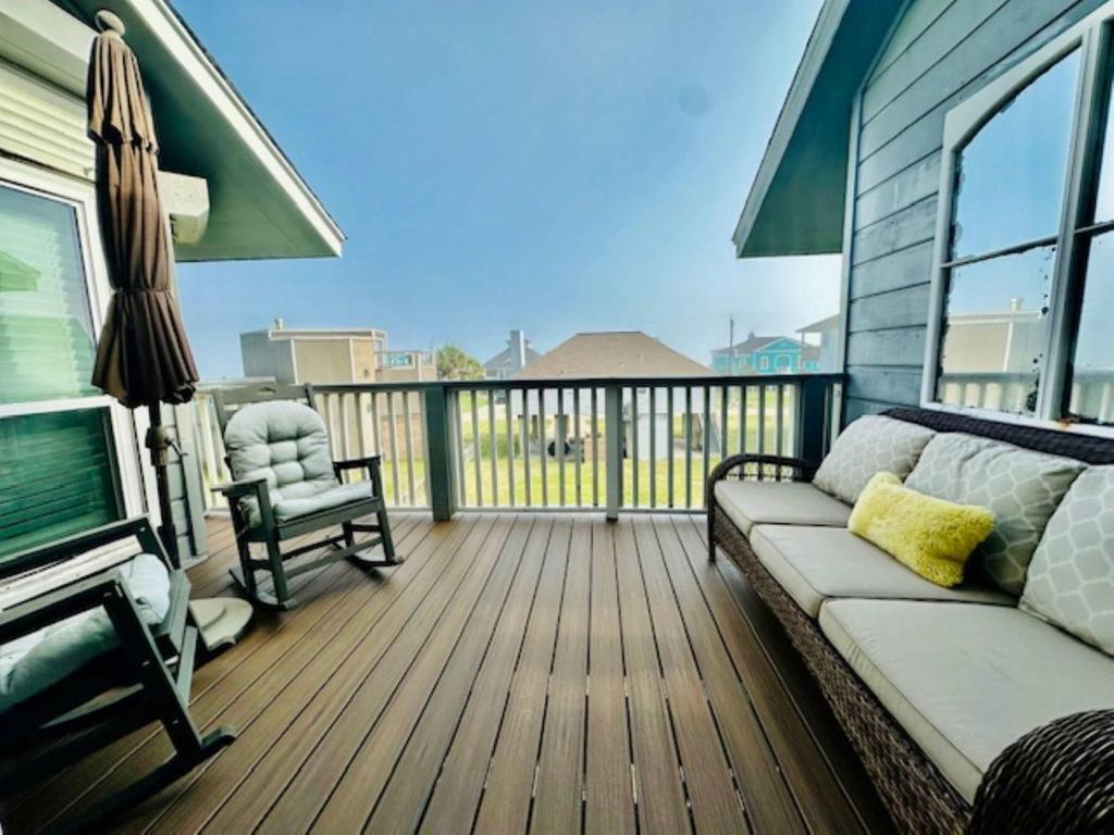 a porch with a couch and a chair on a deck at Shipwrecked Getaway For 6 in Galveston