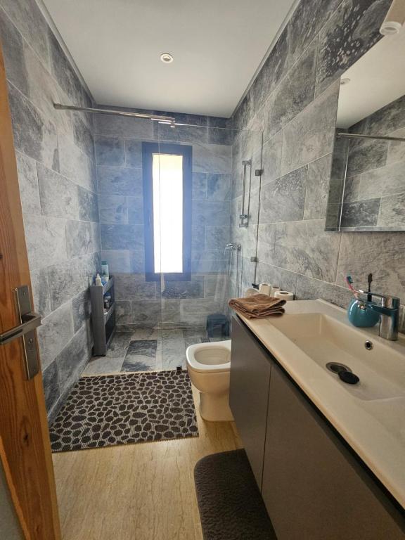 a bathroom with a shower and a toilet and a sink at Villa in Aït Bou Zguia