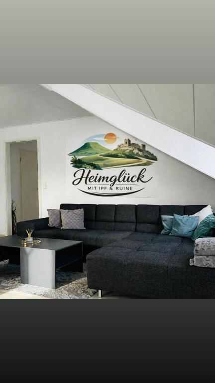 a living room with couches and a sign on the wall at Heimglück mit Ipf & Ruine in Bopfingen