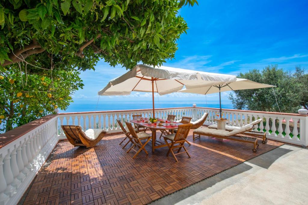a patio with a table and chairs and an umbrella at Oasi Milano in Furore