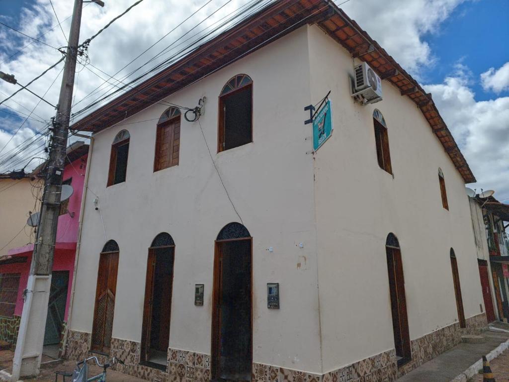 a white building with brown windows on a street at Belvedere das Estrelas in Lençóis